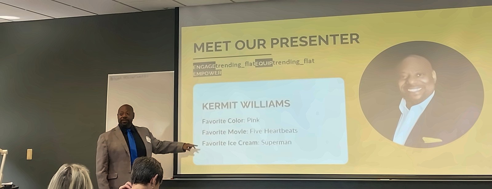 Kermit Williams presenting to an audience, standing beside a slide that reads Meet Our Presenter